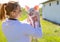 Woman vet holding adorable piglet over shoulder smiling on farm