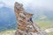 Woman on via ferrata Cesare Piazzetta, standing on a pointy rock above the winding road at Pordoi pass, Dolomites mountains, Italy