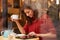 Woman Viewed Through Window Of Cafï¿½ Using Digital Tablet