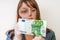 Woman viewing counterfeit banknote with magnifying glass