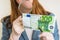 Woman viewing counterfeit banknote with magnifying glass