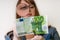 Woman viewing counterfeit banknote with magnifying glass