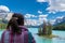 Woman views Spirit Island from the shoreline of Maligne Lake in Jasper National Park