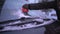 A woman vigorously scrapes the frozen windshield of her car.