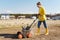 Woman villager is using aerator machine to scarification and aeration of lawn or meadow