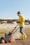 Woman villager is using aerator machine to scarification and aeration of lawn or meadow