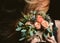 Woman with vintage rustic bouquet of wild roses Carnation flower