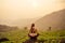 Woman in violet cloth doing yoga on tea plantations in Munnar hill Kerala India