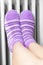 Woman in violet winter socks warm their feet