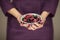 Woman in violett 50`s dress hands holding some raspberries and blackberries