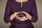 Woman in violett 50`s dress hands holding some raspberries and blackberries