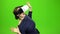 Woman in virtual glasses is watching an interesting film. Green screen