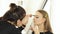 Woman visagiste doing makeup eyebrows and face on for young woman before wedding. Woman visagiste coloring eyebrows on