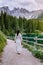 Woman visit hte bleu lake in the dolomites Italy, Carezza lake Lago di Carezza, Karersee with Mount Latemar, Bolzano