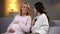 Woman visiting her pregnant friend at home, happy motherhood, baby waiting