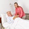 Woman visiting old man in hospital