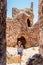 Woman visiting a restored stone castle in a sunny day