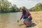 A woman volunteer pulls a bottle out of the water, during the event to clean the river Bank. Earth day and environmental