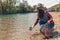 A woman volunteer pulls a bottle out of the water, during the event to clean the river Bank. Earth day and environmental