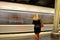 Woman waiting in front of moving subway train