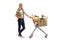 Woman waiting in line with shopping cart and paper bag