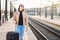 Woman waiting for train at station. Happy smiling lady.