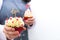 Woman waitress with two cupcakes decorated with red hearts topping and wooden sign with LOVE letters. Valentine`s Day. White