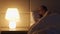 Woman wakes up at midnight switching on bright lamp