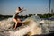 woman wakesurfer skilfully riding on splashing wave on a warm day