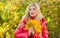 Woman walk in autumn park. Girl makeup dreamy face hold bunch maple leaves. Lady posing with leaves autumn nature