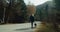 Woman walk with domestic dog on leash at vacation mountain trip on autumn