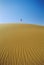 Woman walking across desert sand dune