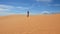 Woman walking across the sand dunes