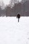 Woman walking across snow covered field