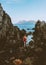 Woman walking alone looking at sea rocks coast in Norway enjoying ocean view