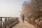 Woman walking alone on rural misty path