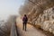 Woman walking alone on rural misty path