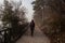 Woman walking alone on rural misty path