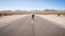 Woman walking alone on street in the middle of nowhere.