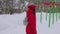 Woman walking alone in winter landscape in moody weather hiking girl wearing red jacket with hood walk in snowy