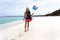 Woman walking along idyllic beach with Australian flag