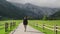 Woman walking along a rural road in the Alpine landscape, Logar Valley, Slovenia