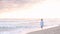 Woman walking along sunset beach