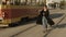 Woman walking along tram rails