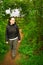 Woman walking through arch in hedge in countryside