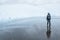 Woman walking around in the rain on a glacier mud flat in the cold