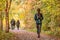 Woman walking in autumn forest nature path walk on trail woods background. Happy girl relaxing on active outdoor