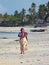 Woman walking away from camera on tropical beach, Jambiani, Zanzibar