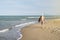 Woman walking away on the idylic beach.