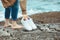 woman walking barefoot by seaside holding hands white shoes. summer vacation